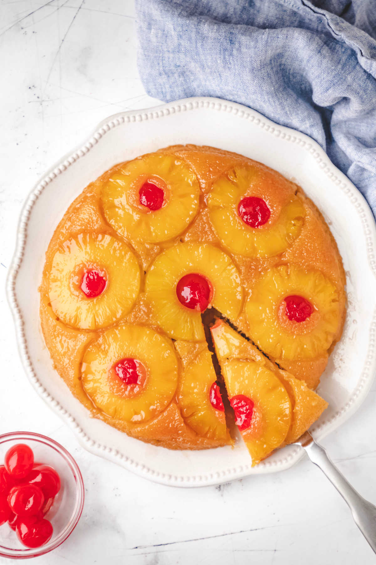 A pineapple upside down cake on a white platter. 