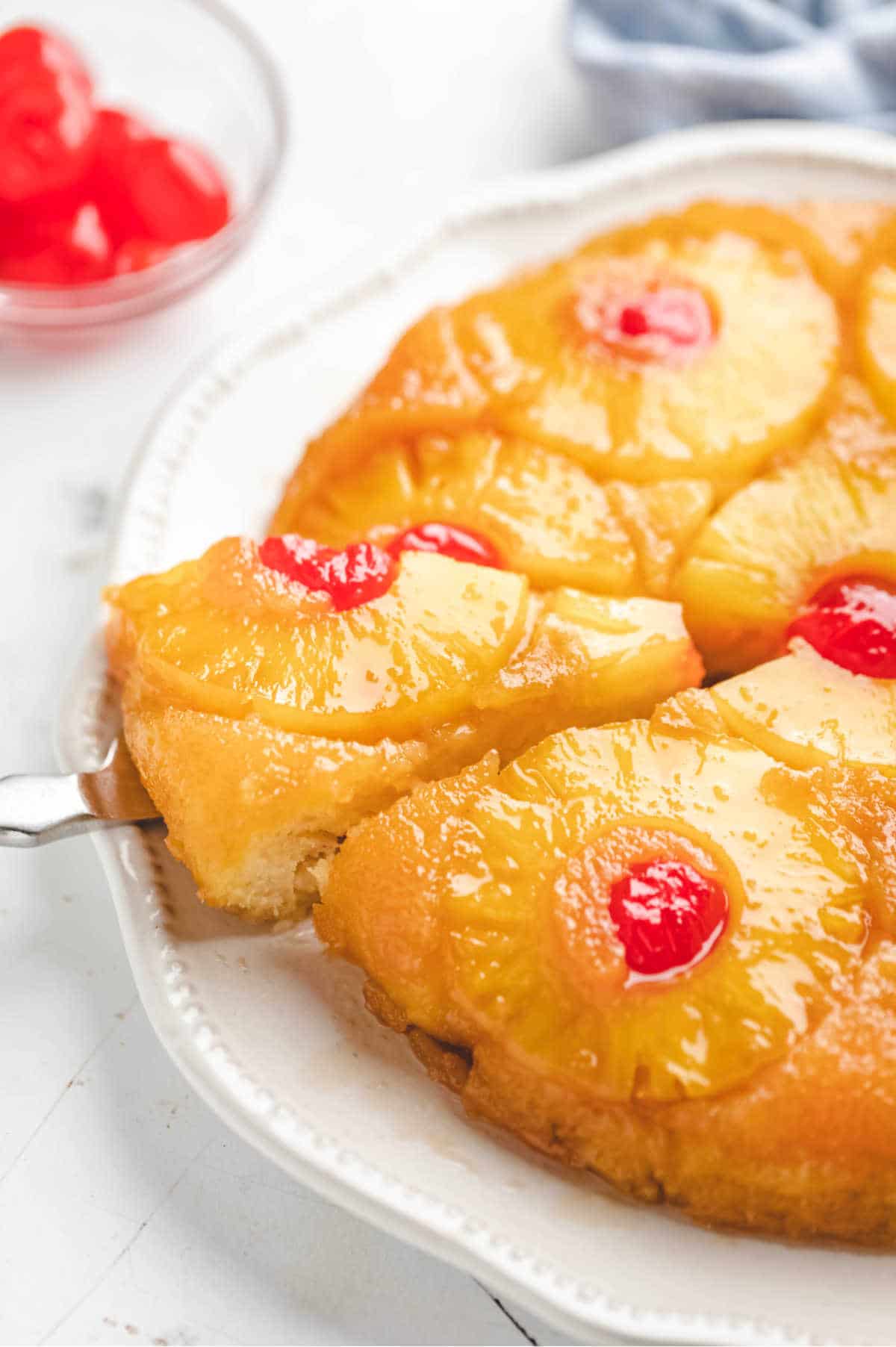 A knife removing a piece of pineapple upside down cake.