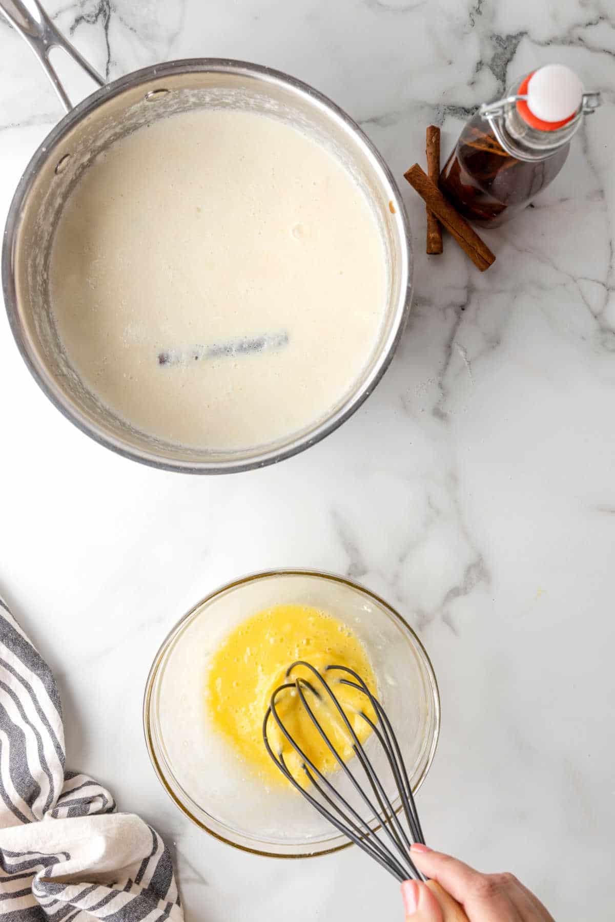 A whisk whisking an egg in a small glass disk.