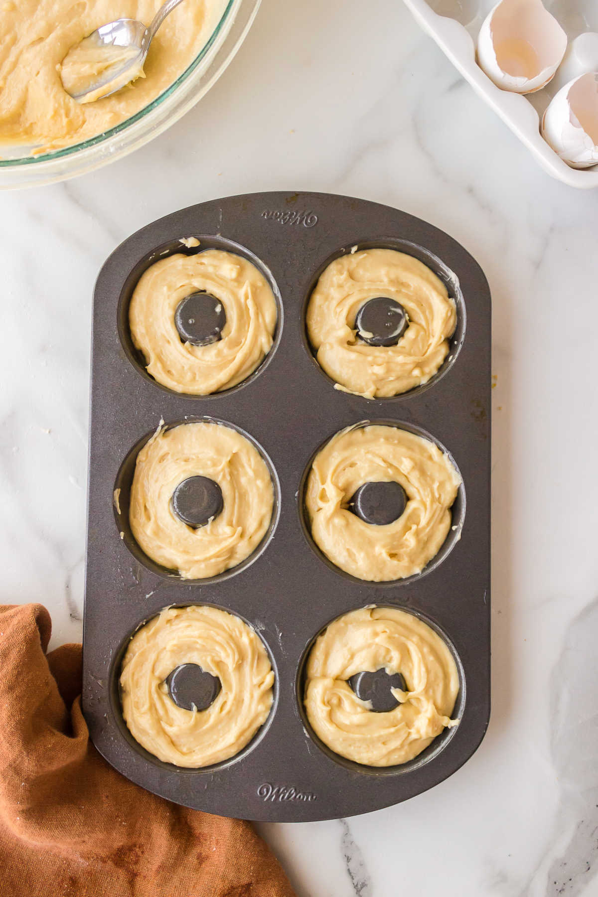 Churro donut batter in a donut pan.