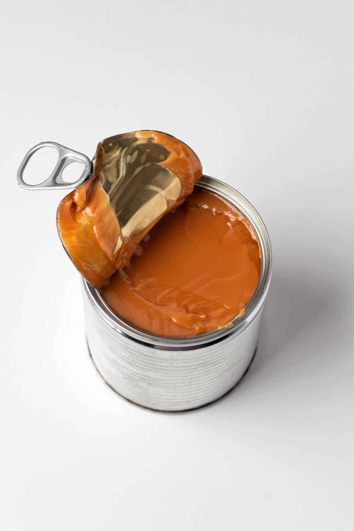 Dulce de leche in an aluminum can with the lid open. 