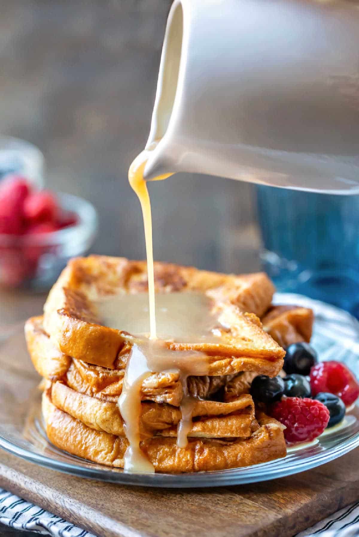 Buttermilk syrup pouring onto a stack of French toast.