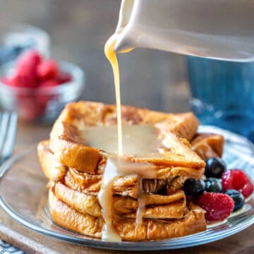 Buttermilk syrup on French toast next to fresh berries.