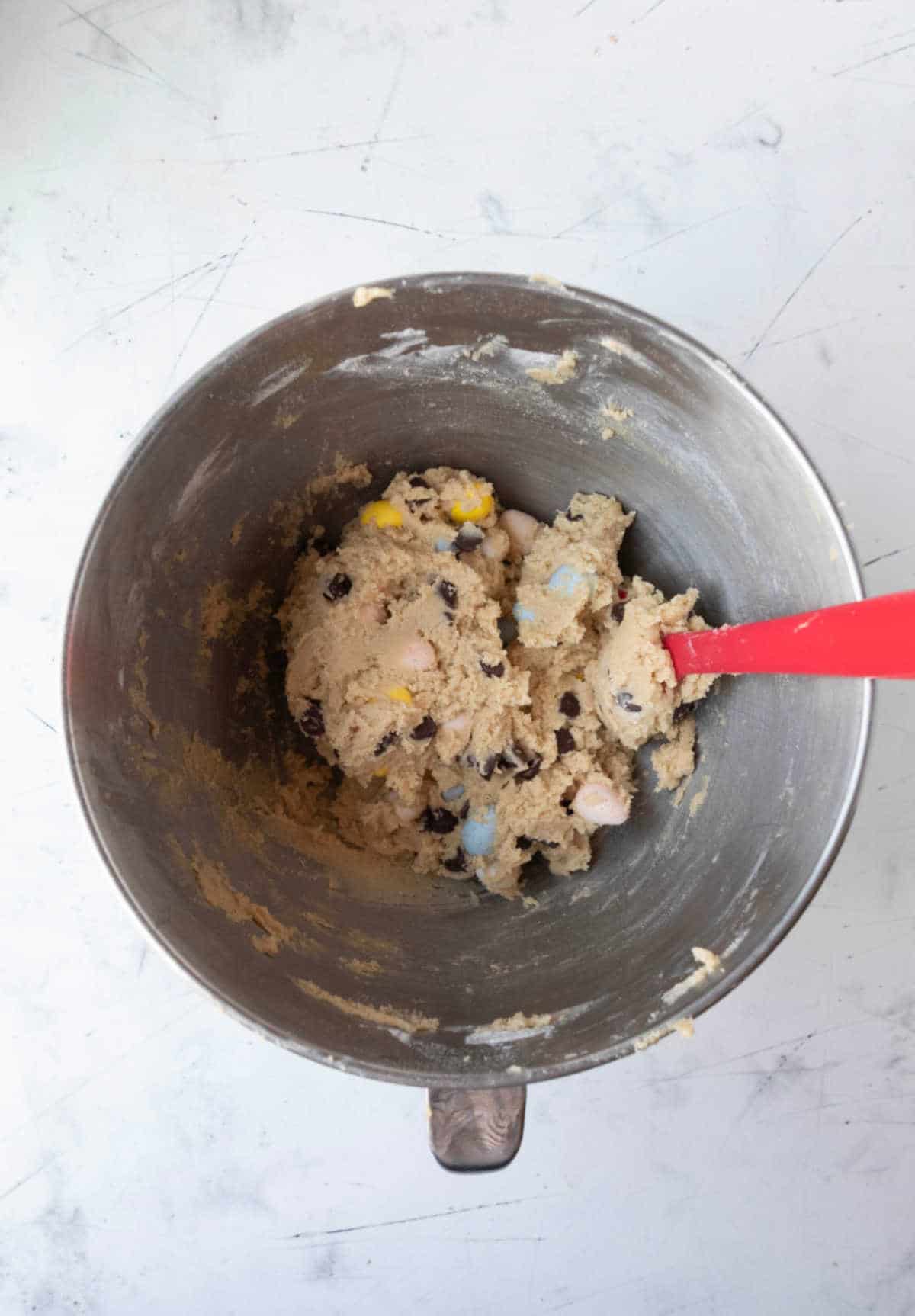 Cadbury mini egg cookie dough in a silver mixing bowl. 