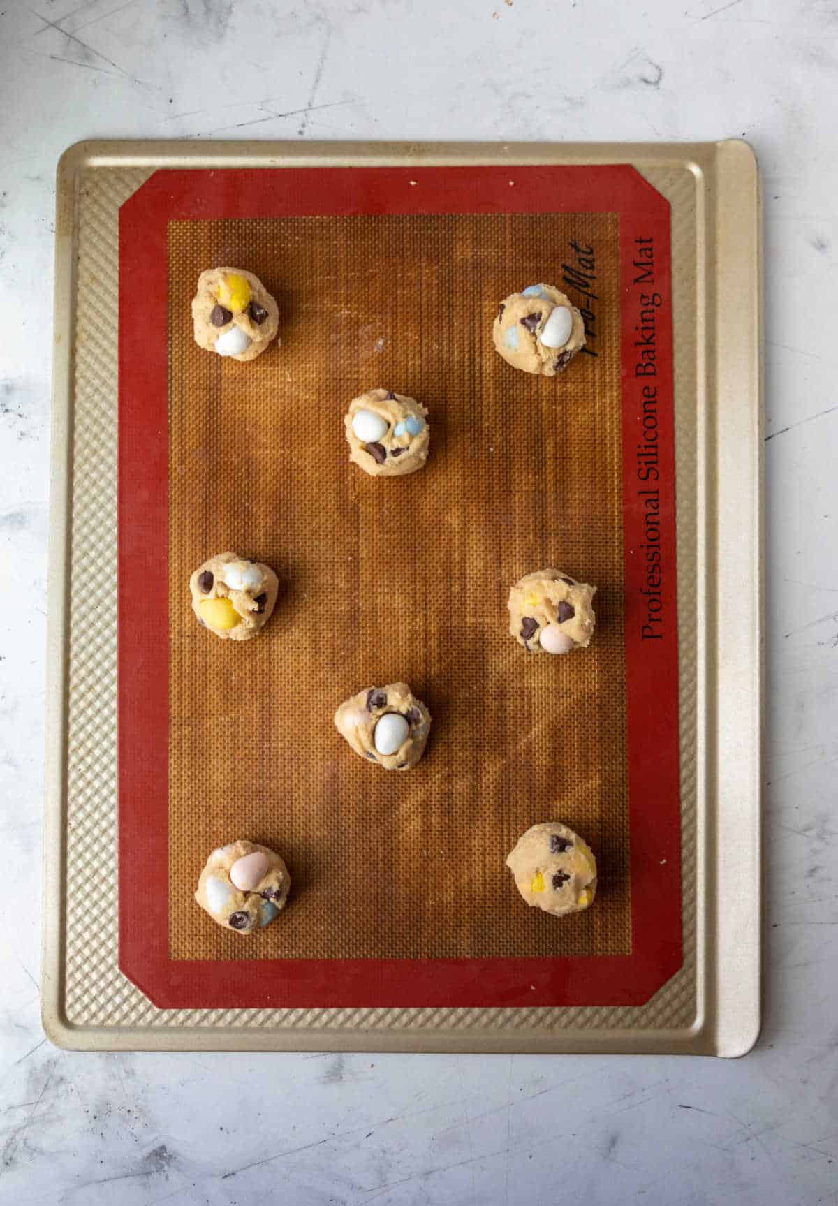 Cadbury mini egg cookie dough on a baking sheet. 