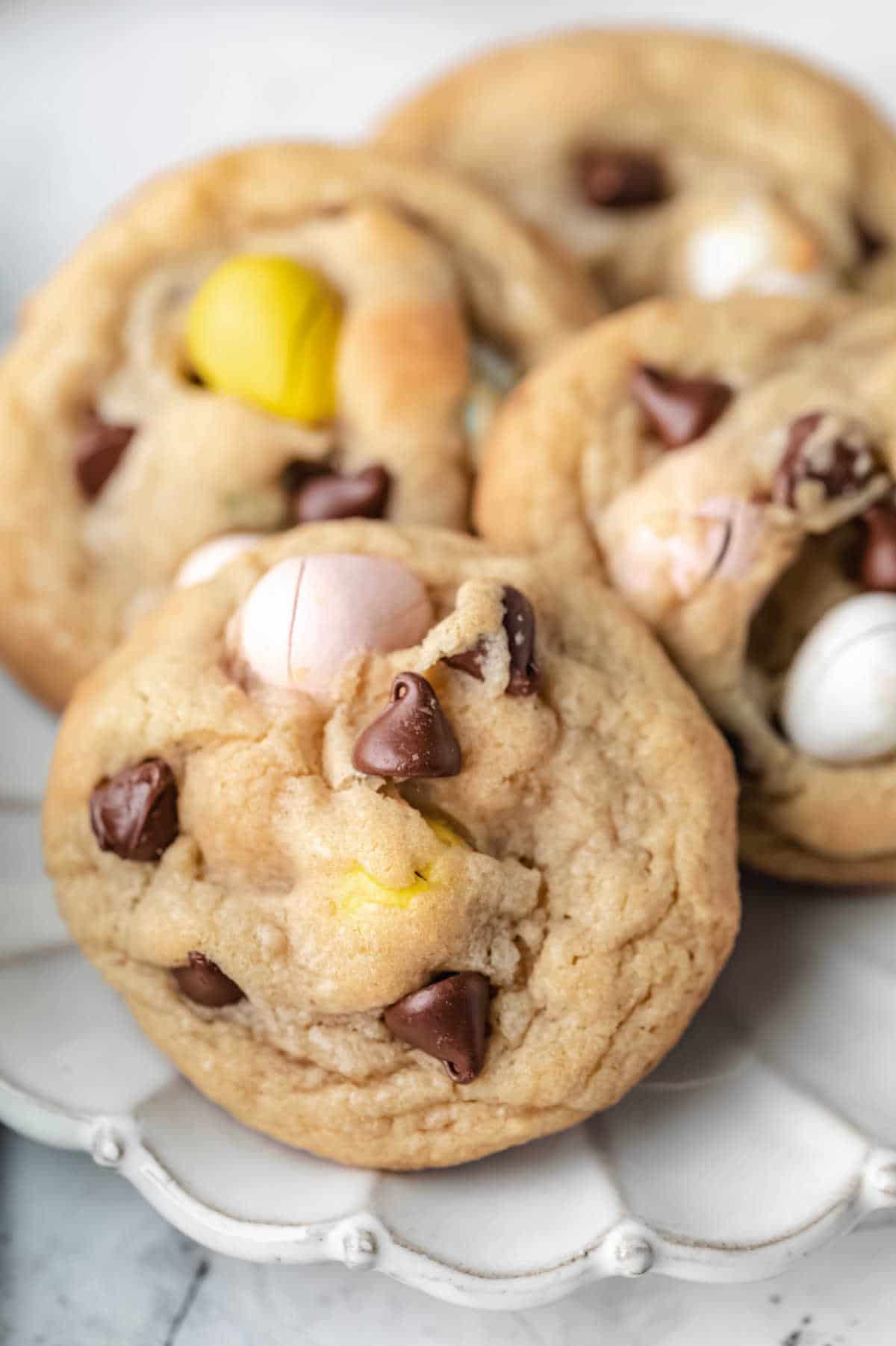 Cadbury mini egg cookies on a scalloped plate. 