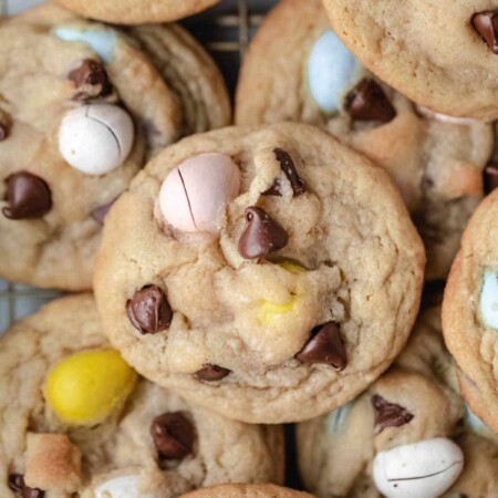 Cadbury egg cookies overlapping on a wire cooling rack.