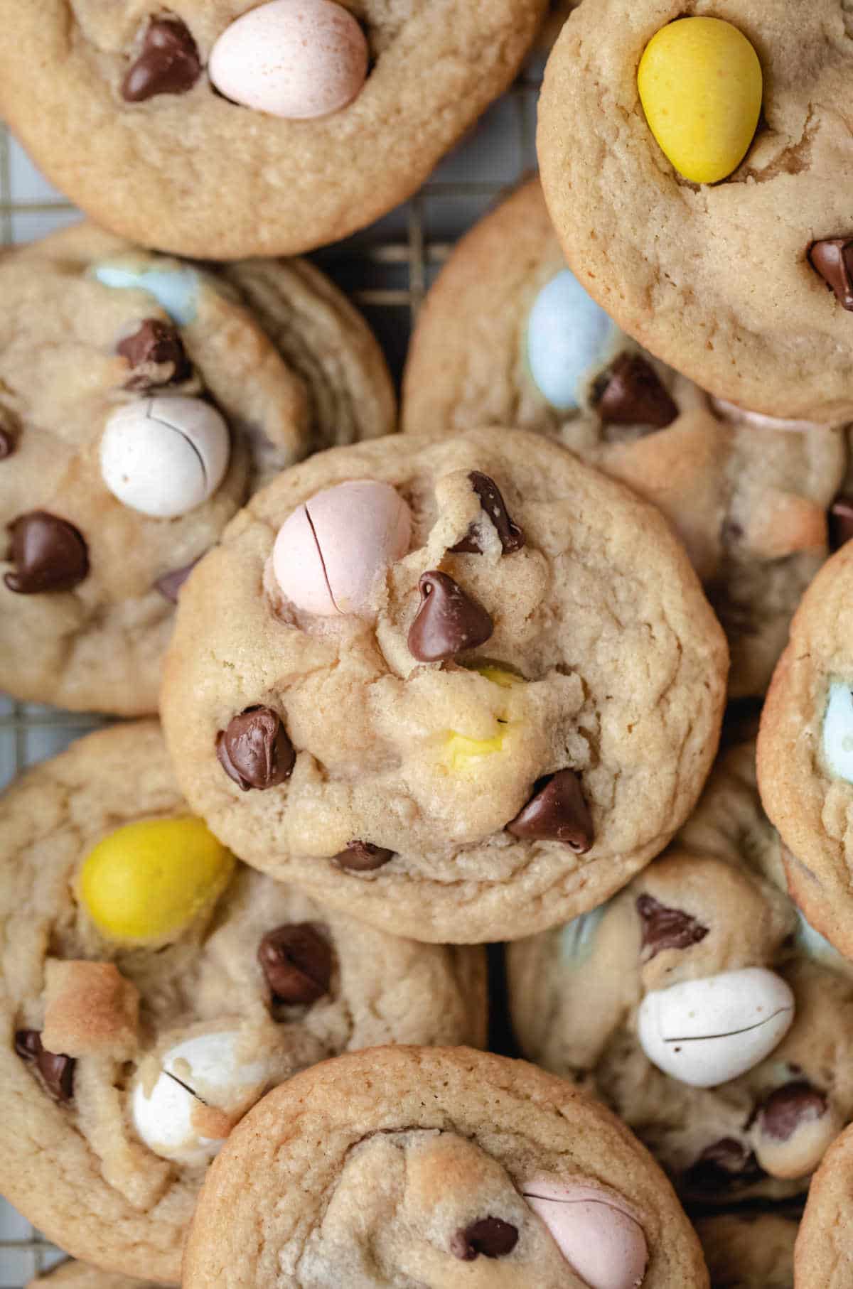 Cadbury egg cookies overlapping on a wire cooling rack.