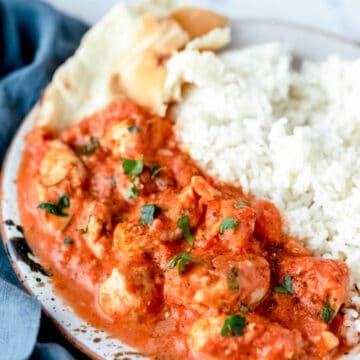 Chicken tikka masala and rice on a plate.