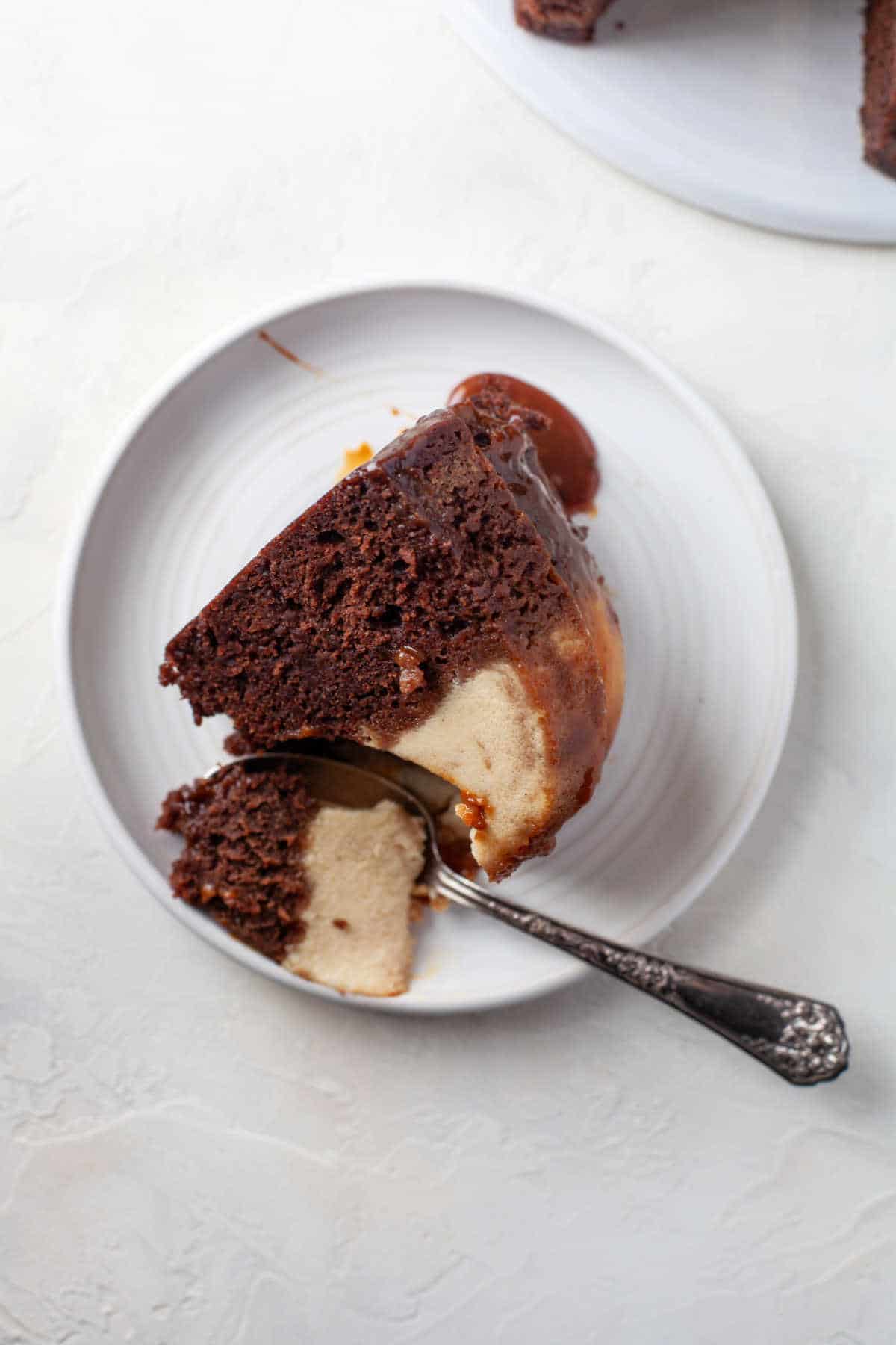 A slice of chocoflan with a spoon taking a bite out.