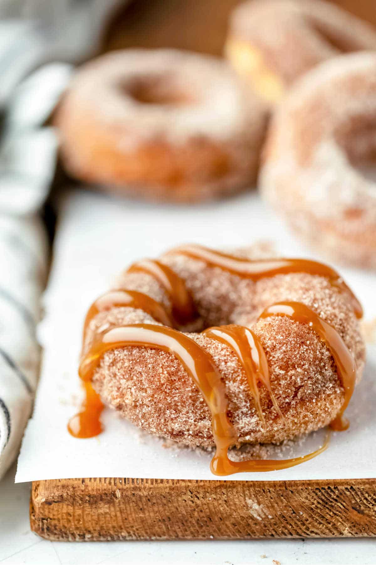 Baked churro donuts on a piece of parchment paper. 