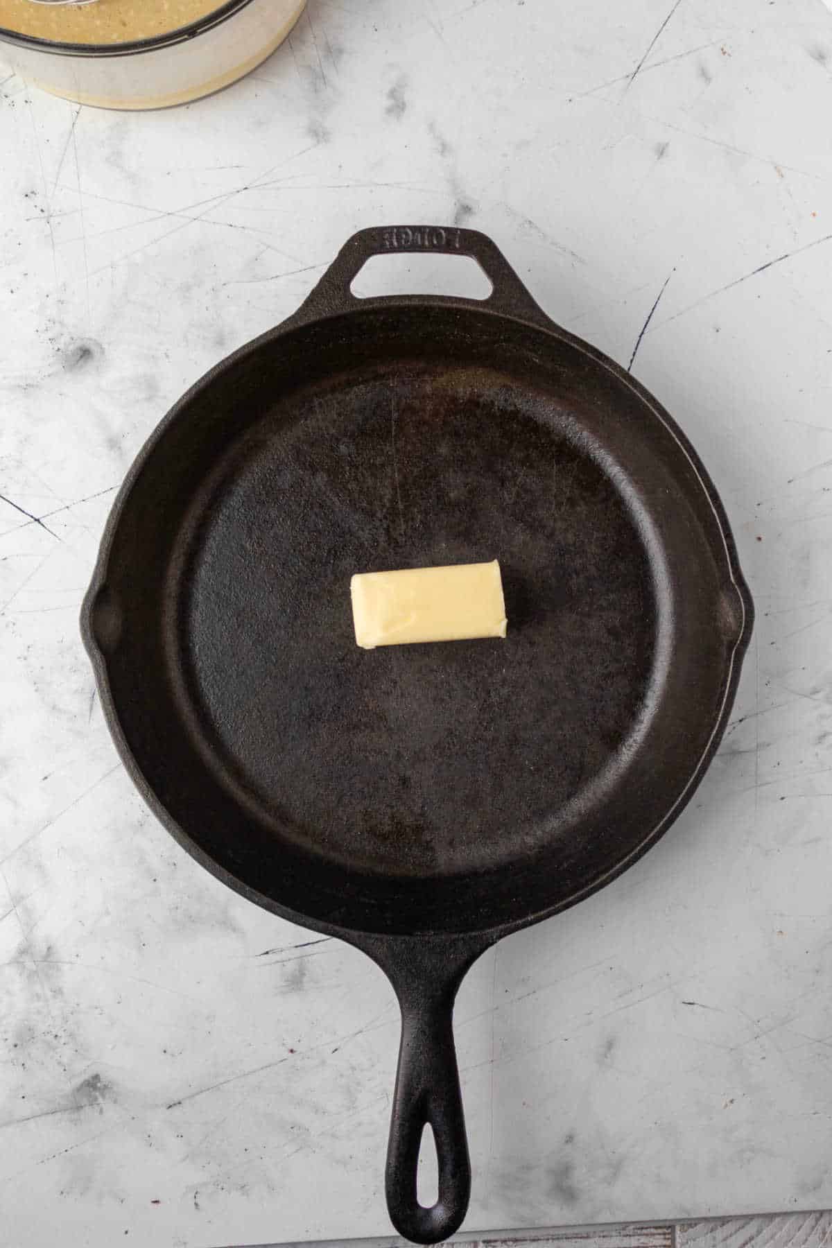 Half of a stick of butter in a cast iron skillet.