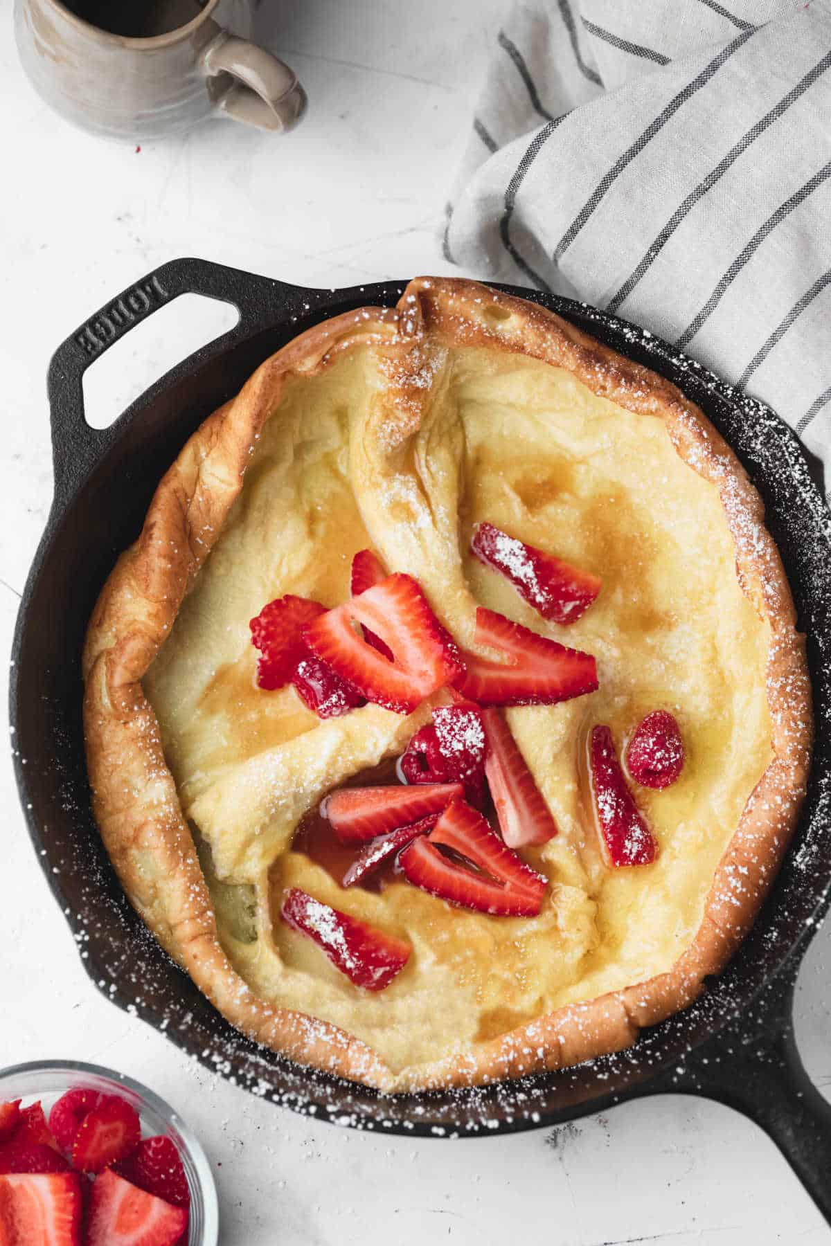 A German pancake topped with strawberries and powdered sugar. 
