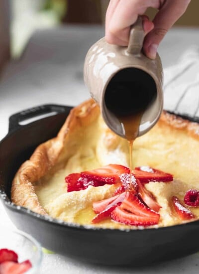 Maple syrup pouring onto a German puff pancake.