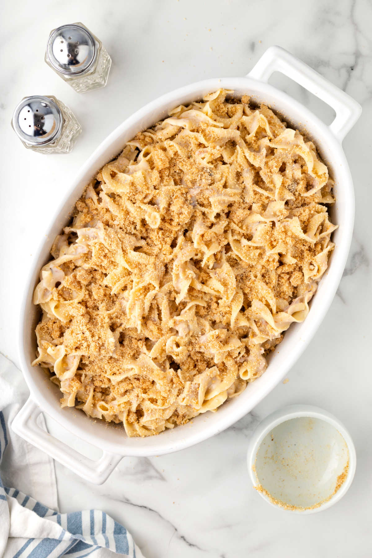Bread crumbs on a dish of unbaked tuna noodle casserole. 