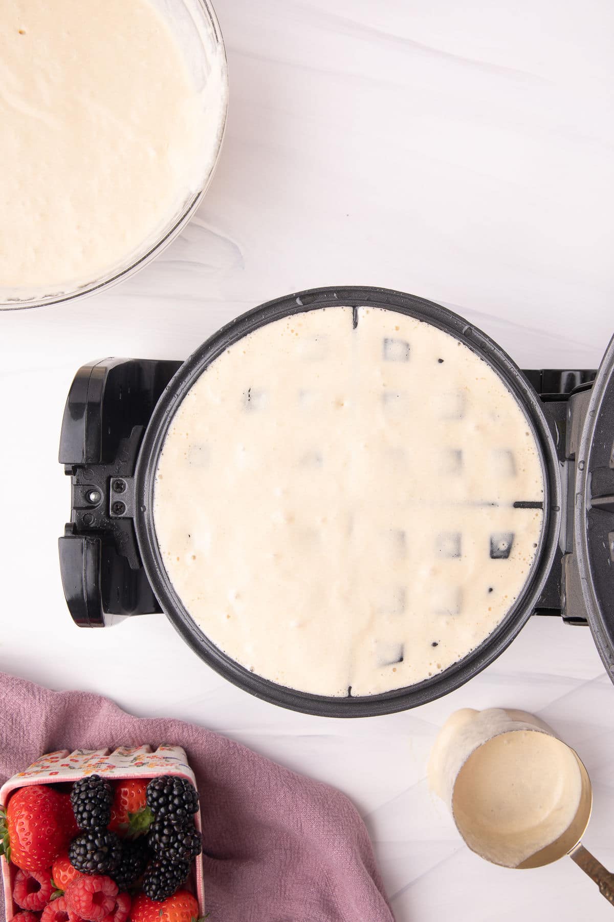 Waffle batter in a Belgian waffle maker. 