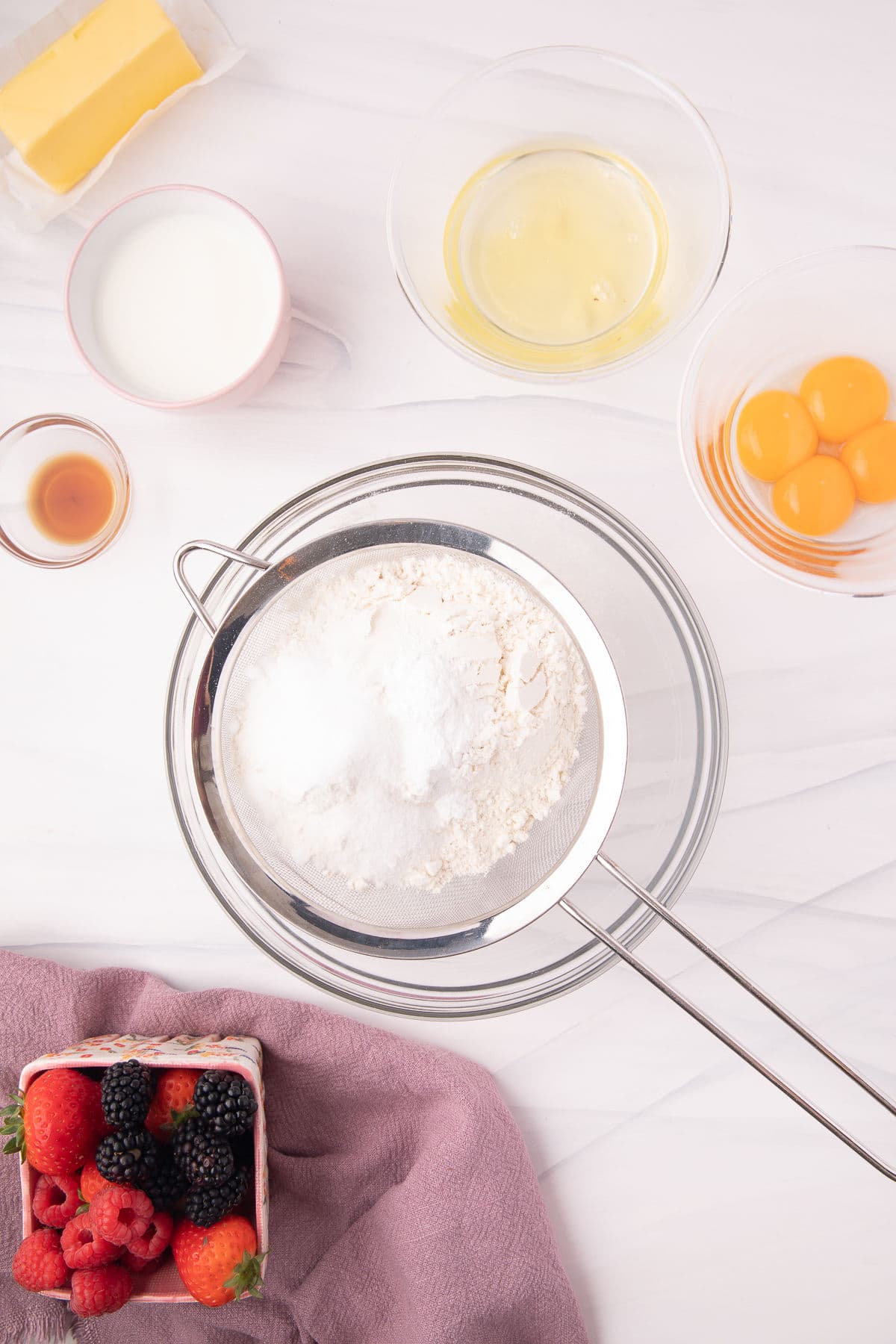 A sifter sifting flour into a bowl. 