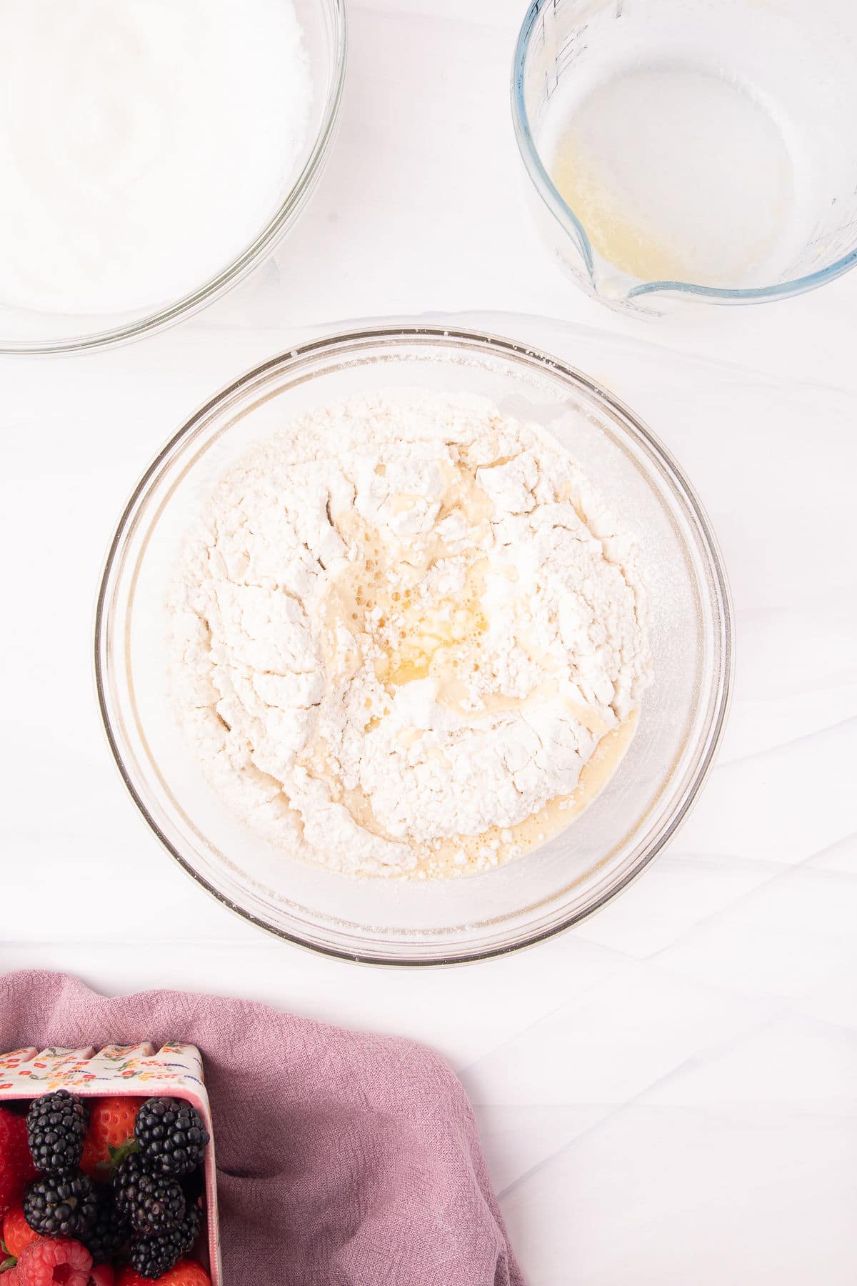 Wet and dry ingredients in a glass mixing bowl.