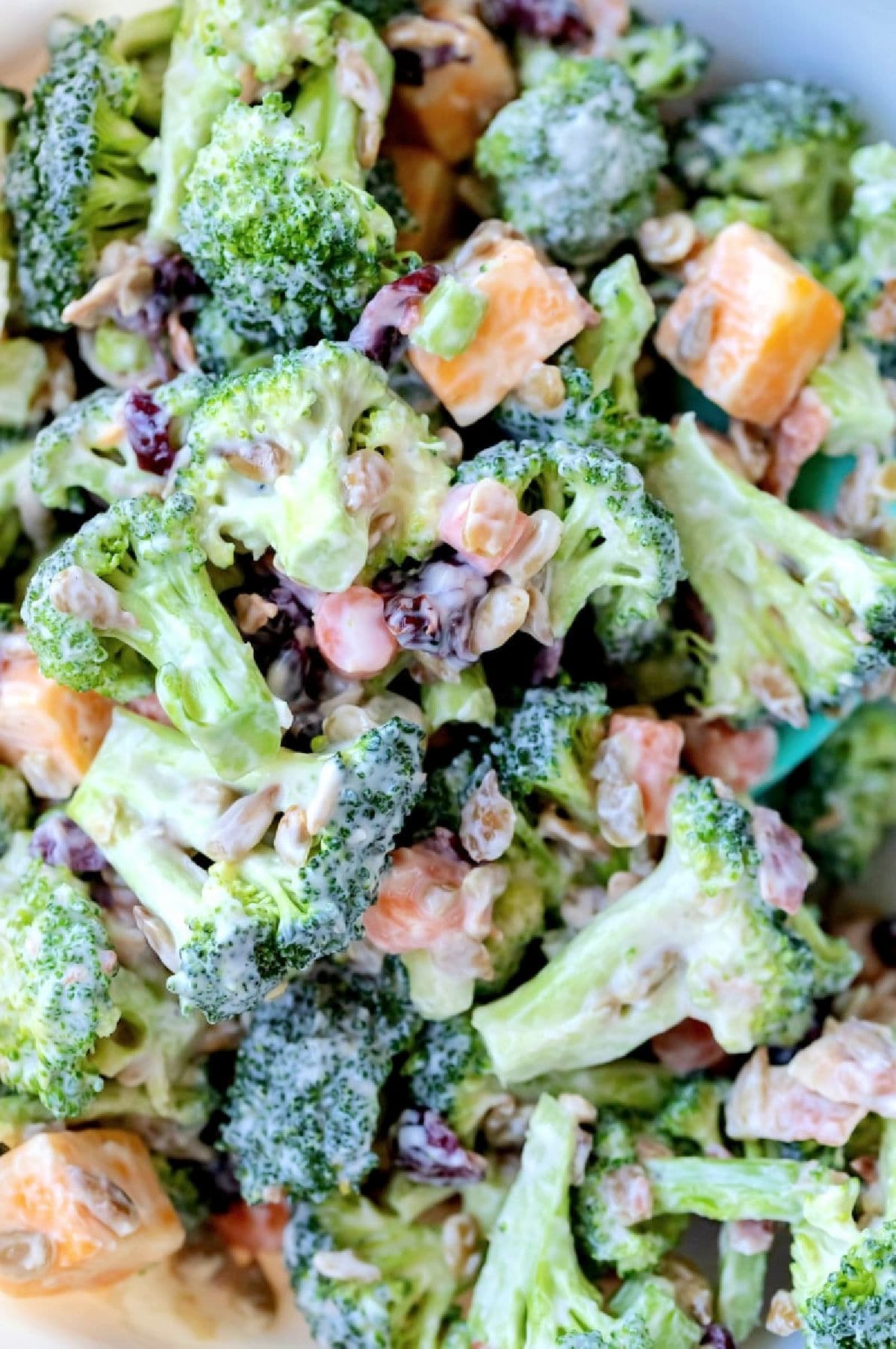 Close up photo of broccoli salad in a mixing bowl. 