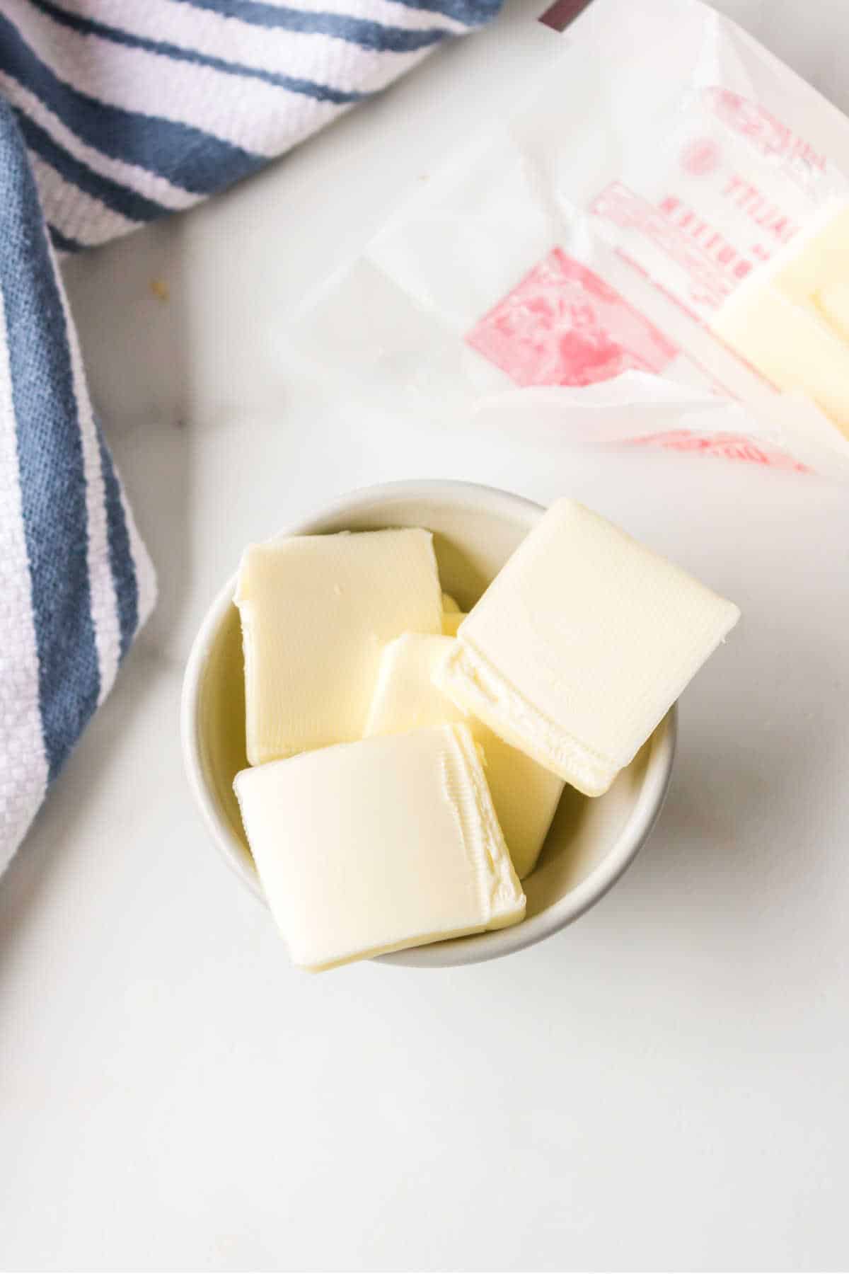 Slices of butter in a white cup. 