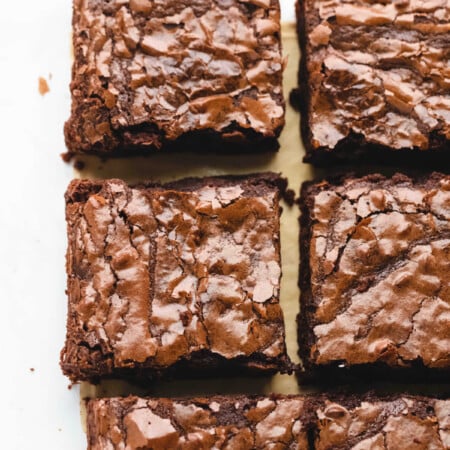 A row of better than box mix brownies on brown parchment paper.