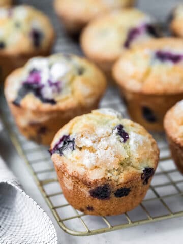 Lemon blueberry muffins next to a checkered linen.