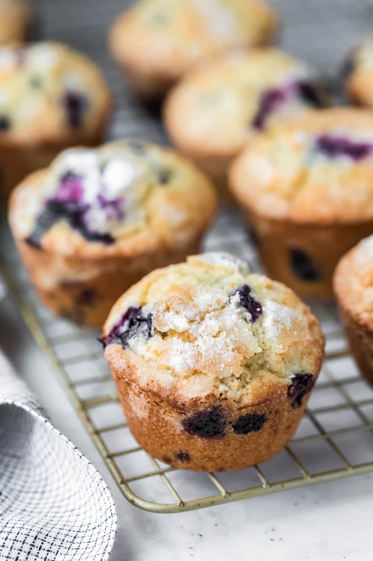 Lemon blueberry muffins next to a checkered linen.