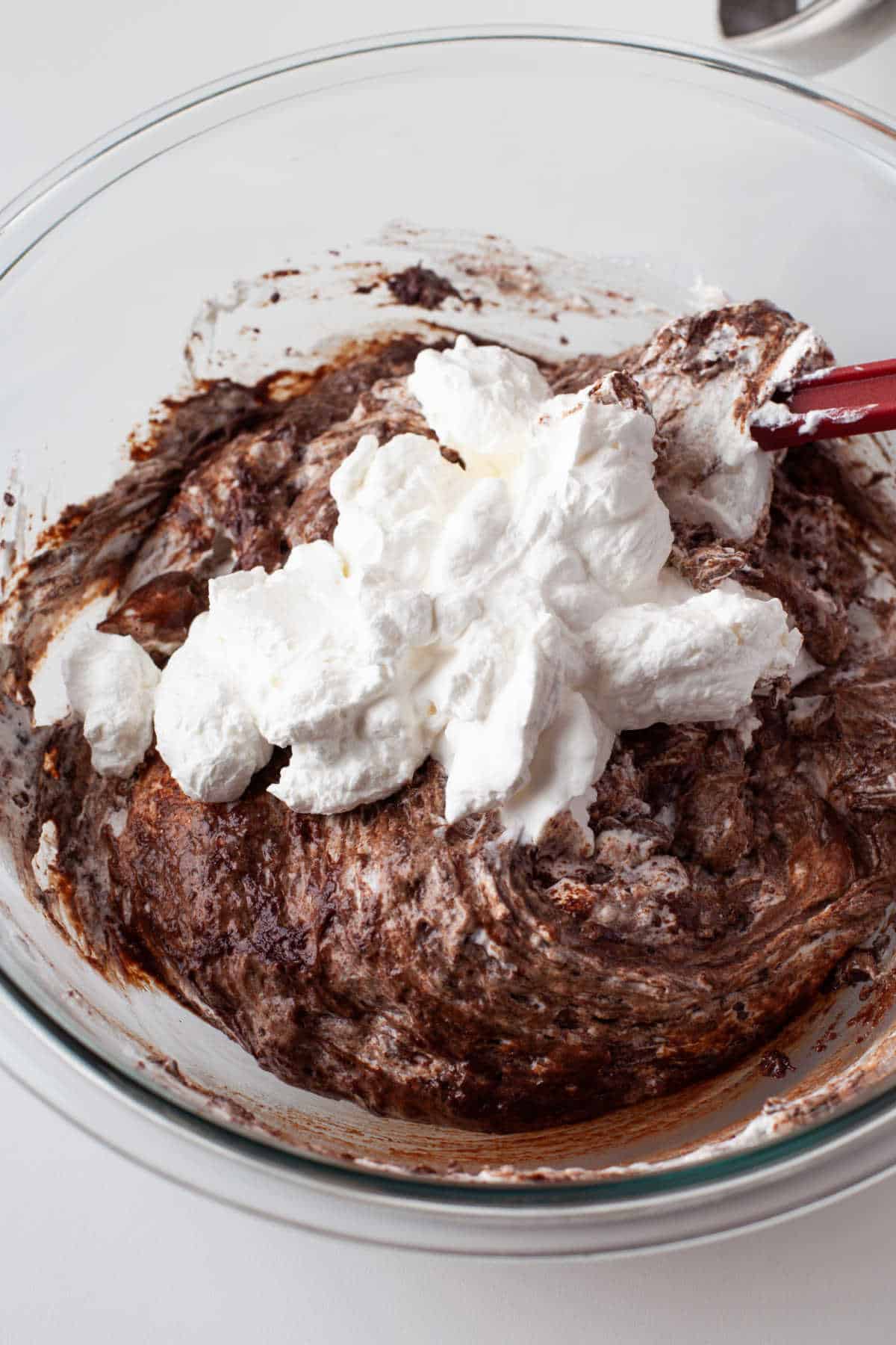 Whipped cream and chocolate mixture in a mixing bowl. 