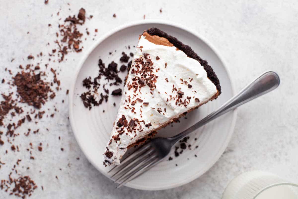 A slice of chocolate pie topped with chocolate shavings.