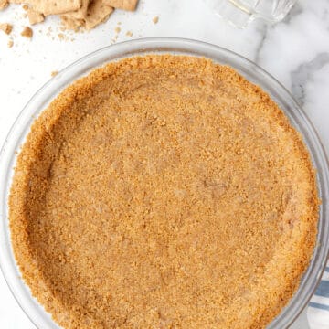 Graham cracker pie crust in a glass pie plate.