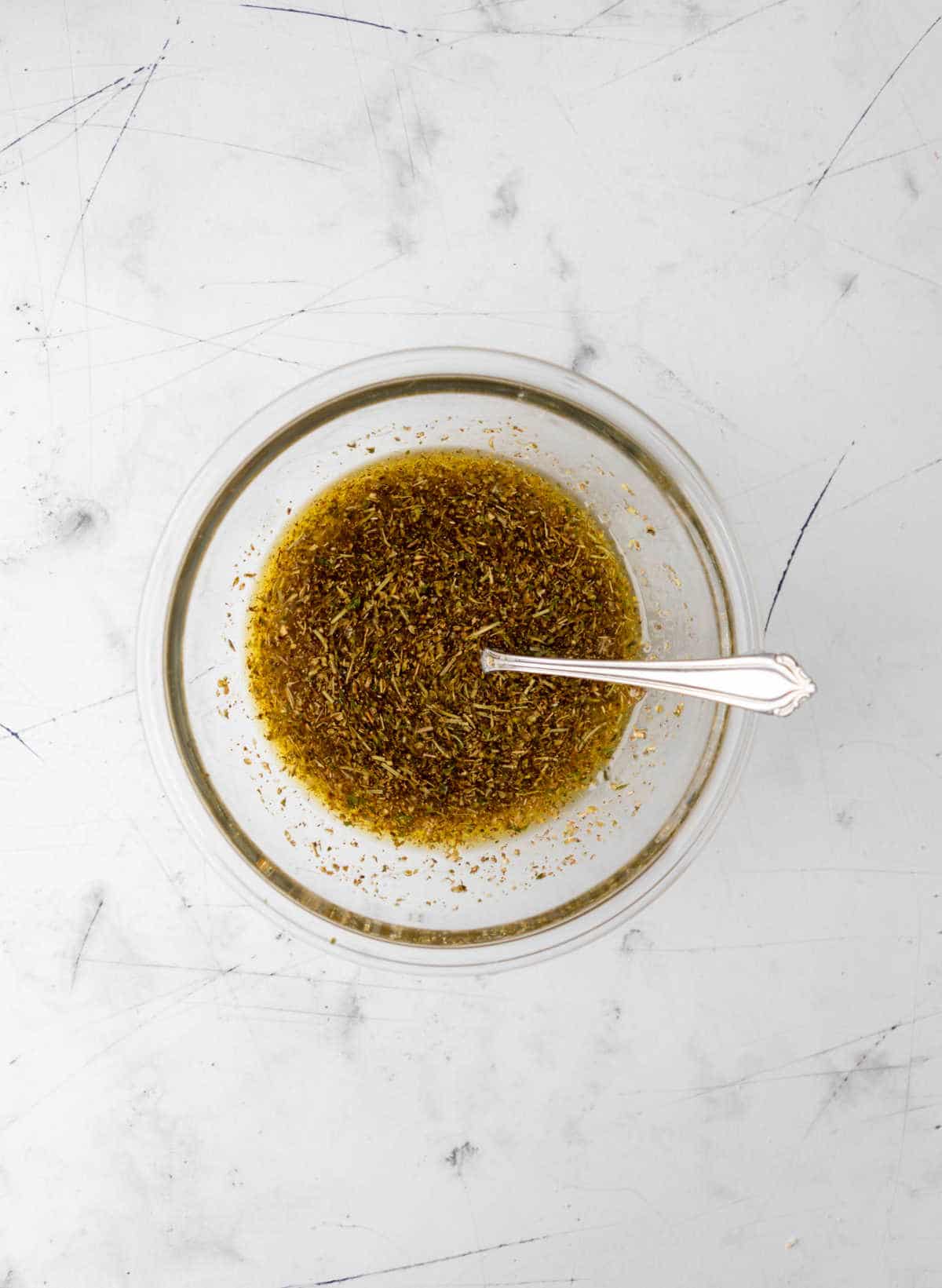 Greek chicken marinade in a glass mixing bowl.