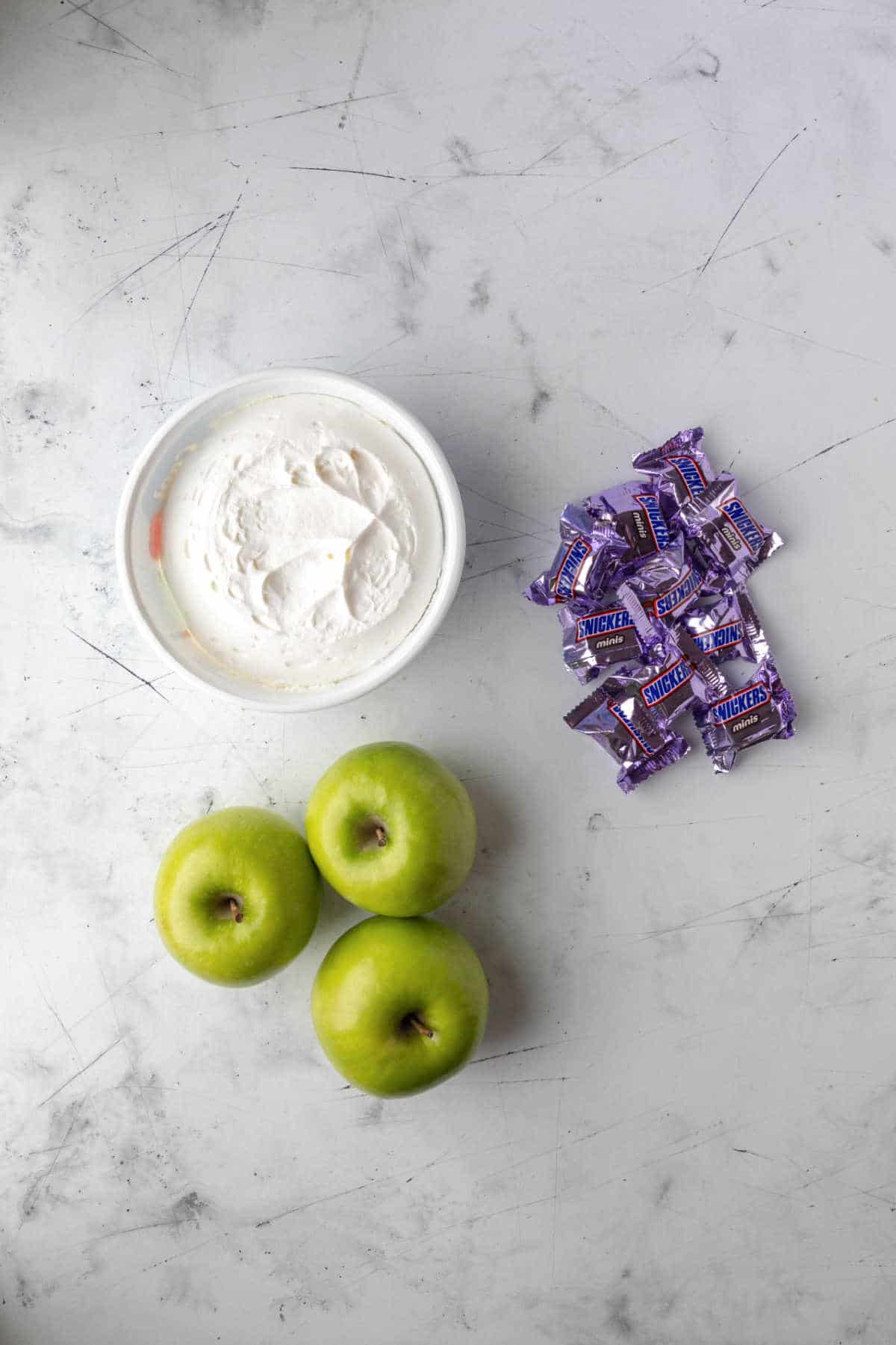 Cool whip green apples and snickers next to each other.