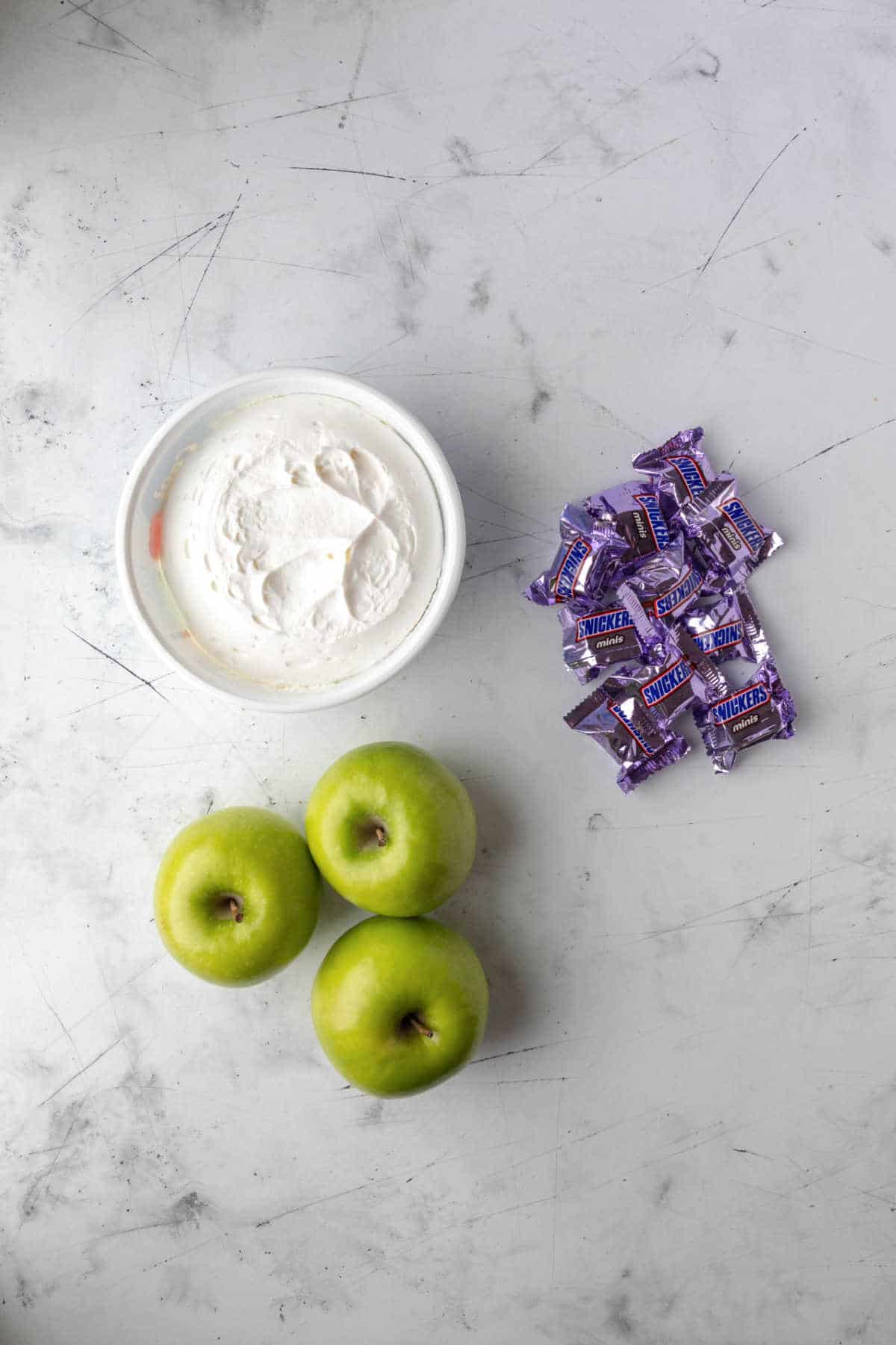 Cool whip green apples and snickers next to each other. 