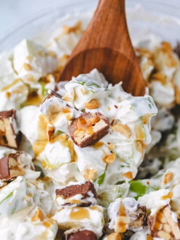 A wooden spoon scooping up snickers salad.