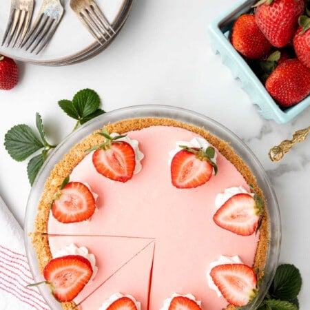 Strawberry jello pie with two slices cut in it.