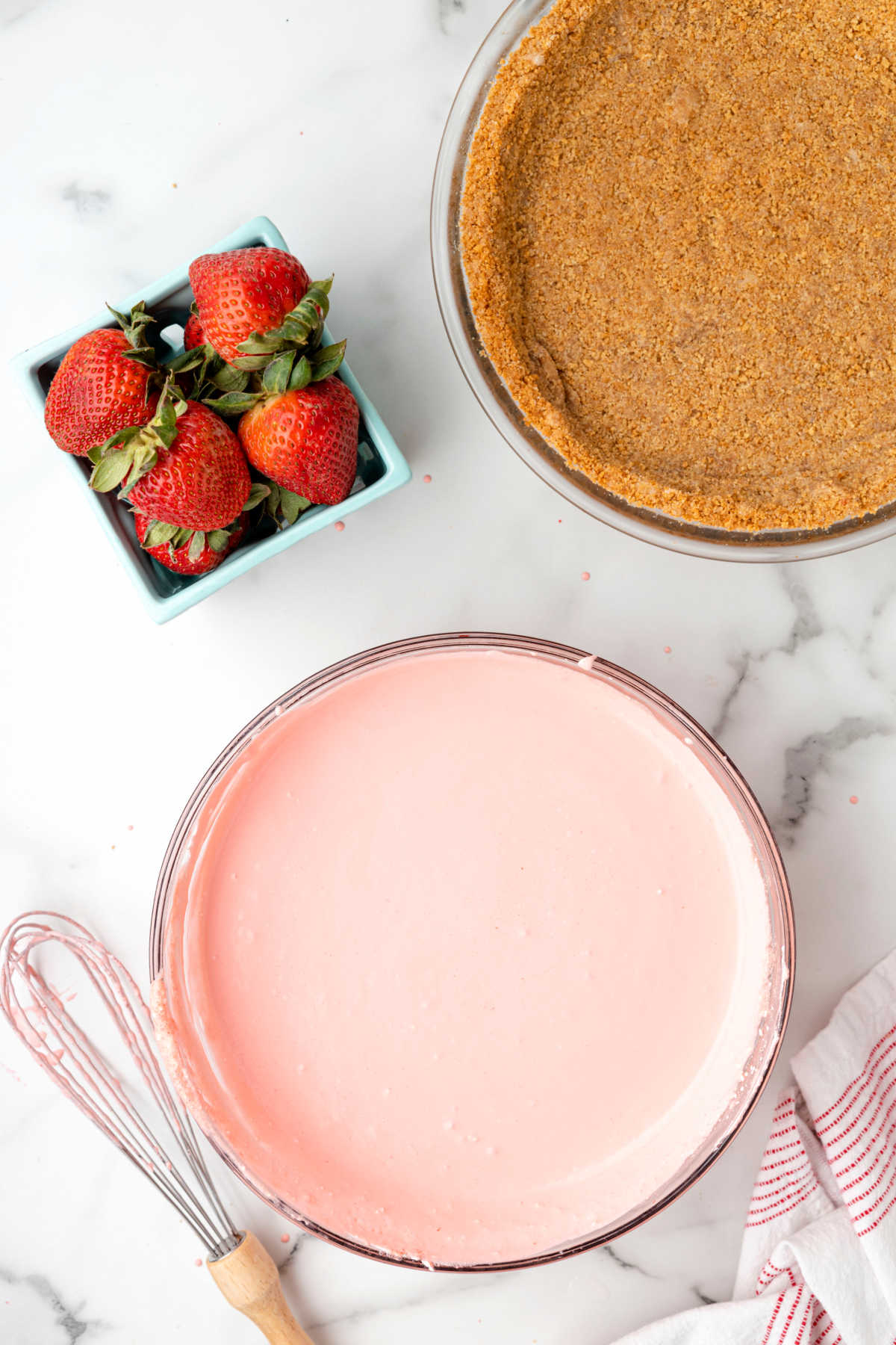 Strawberry jello pie filling mixture in a mixing bowl. 