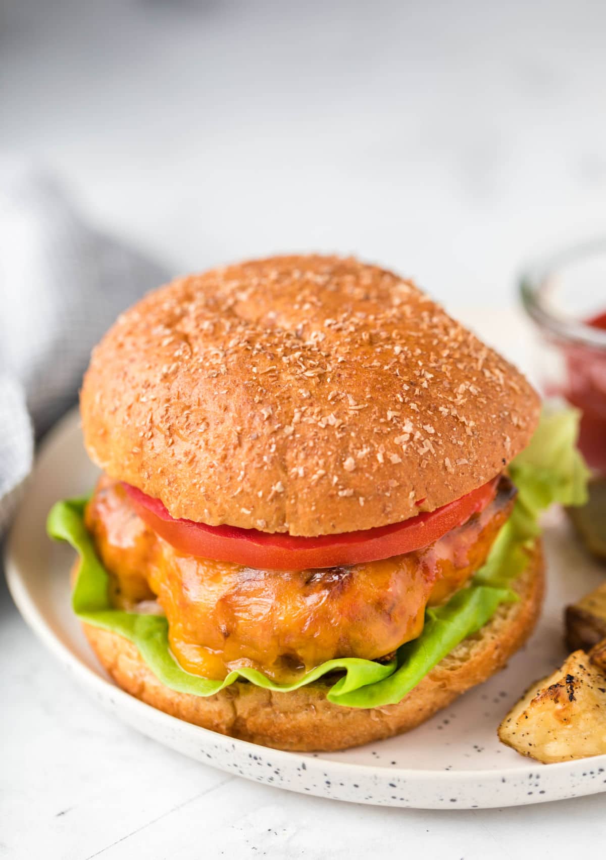 Turkey burger on a white speckled plate. 