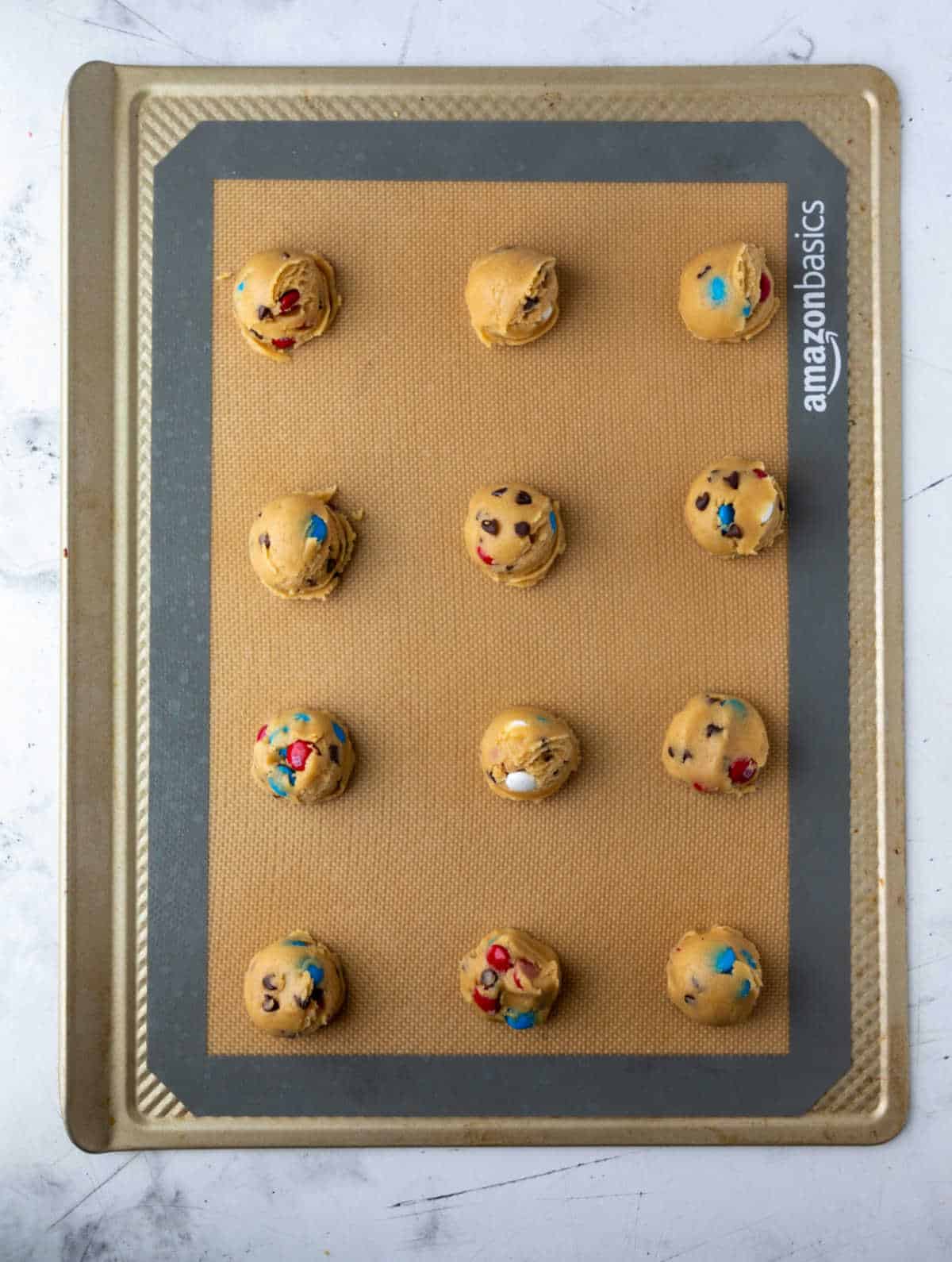 red white and blue cookie dough scoops on a baking sheet. 