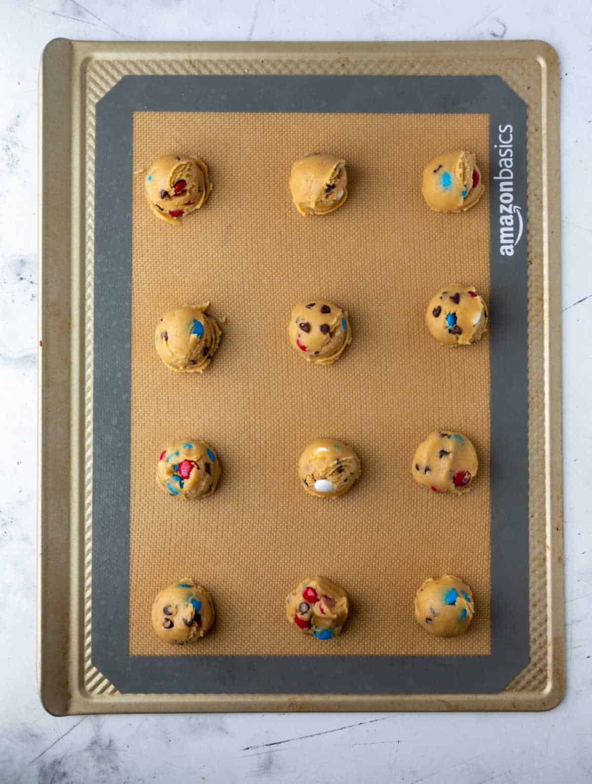 red white and blue cookie dough scoops on a baking sheet.