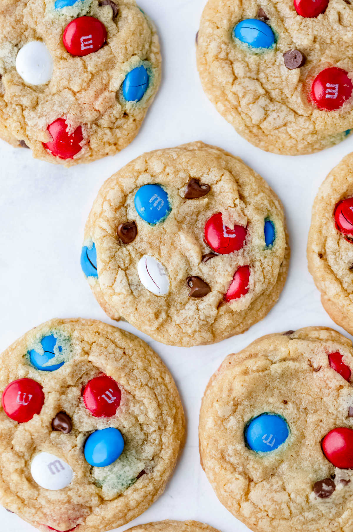 A row of 4th of July M&M cookies on parchment paper. 