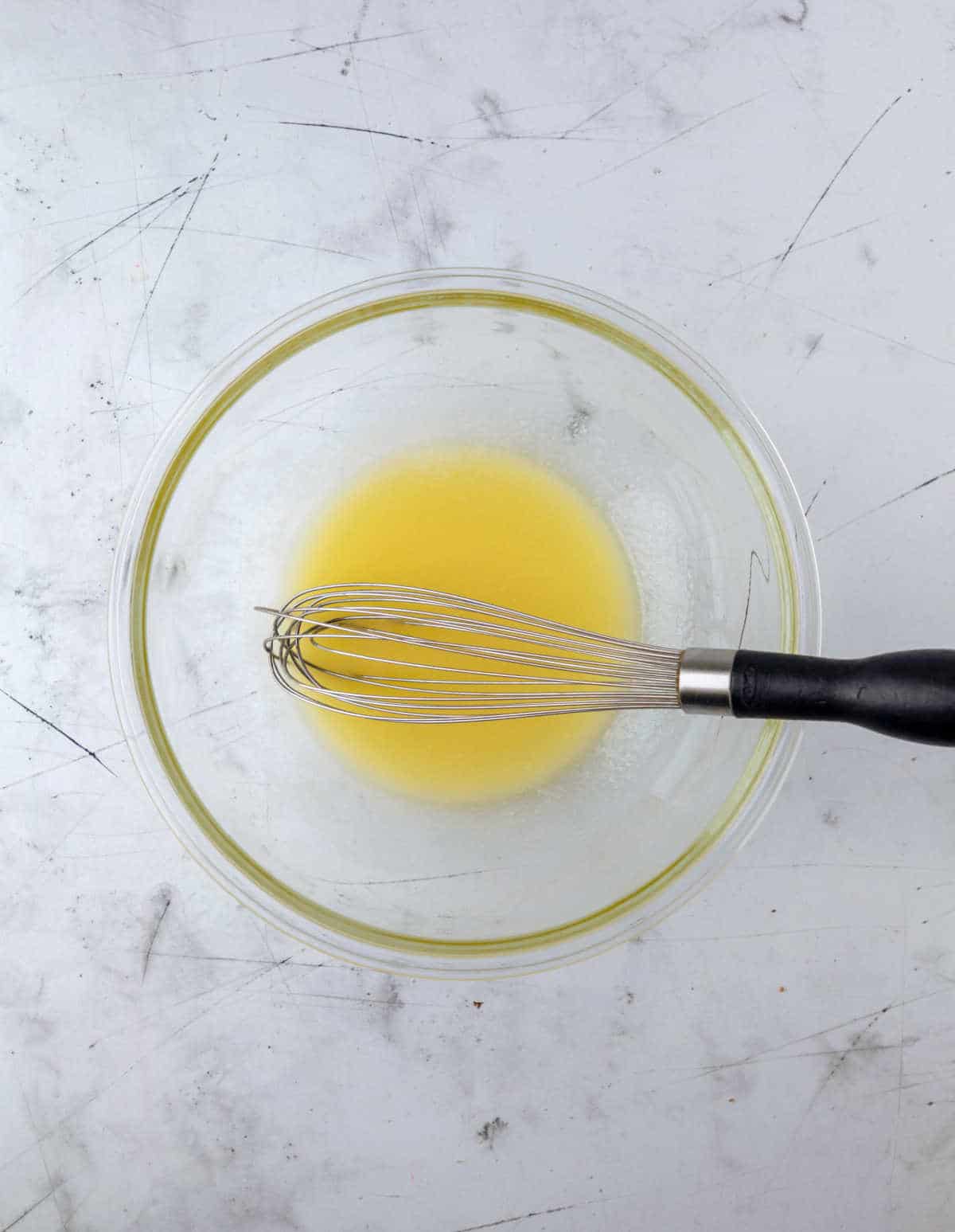 Melted butter in a glass mixing bowl.