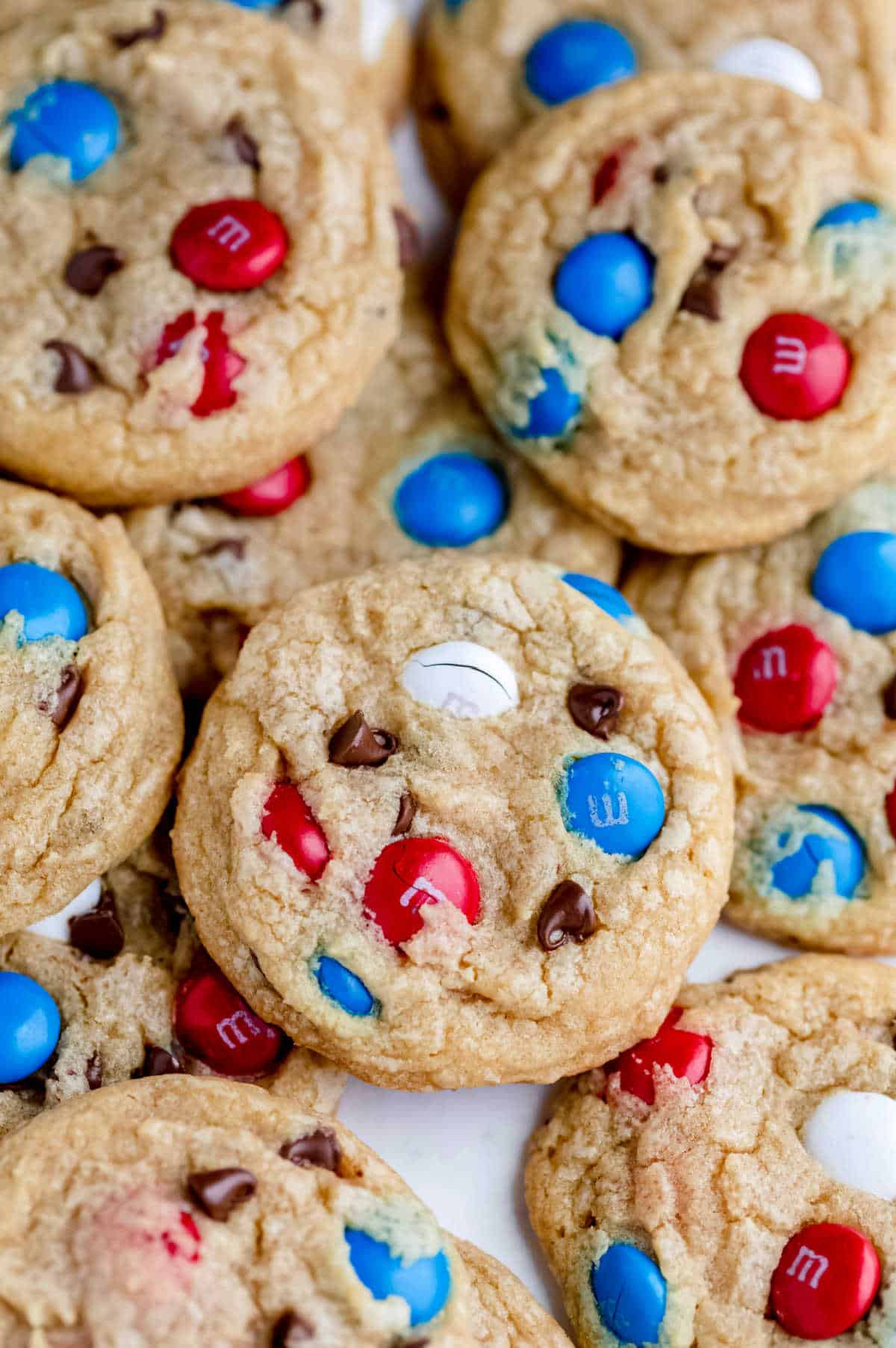 Red white and blue M&M cookies on parchment paper.