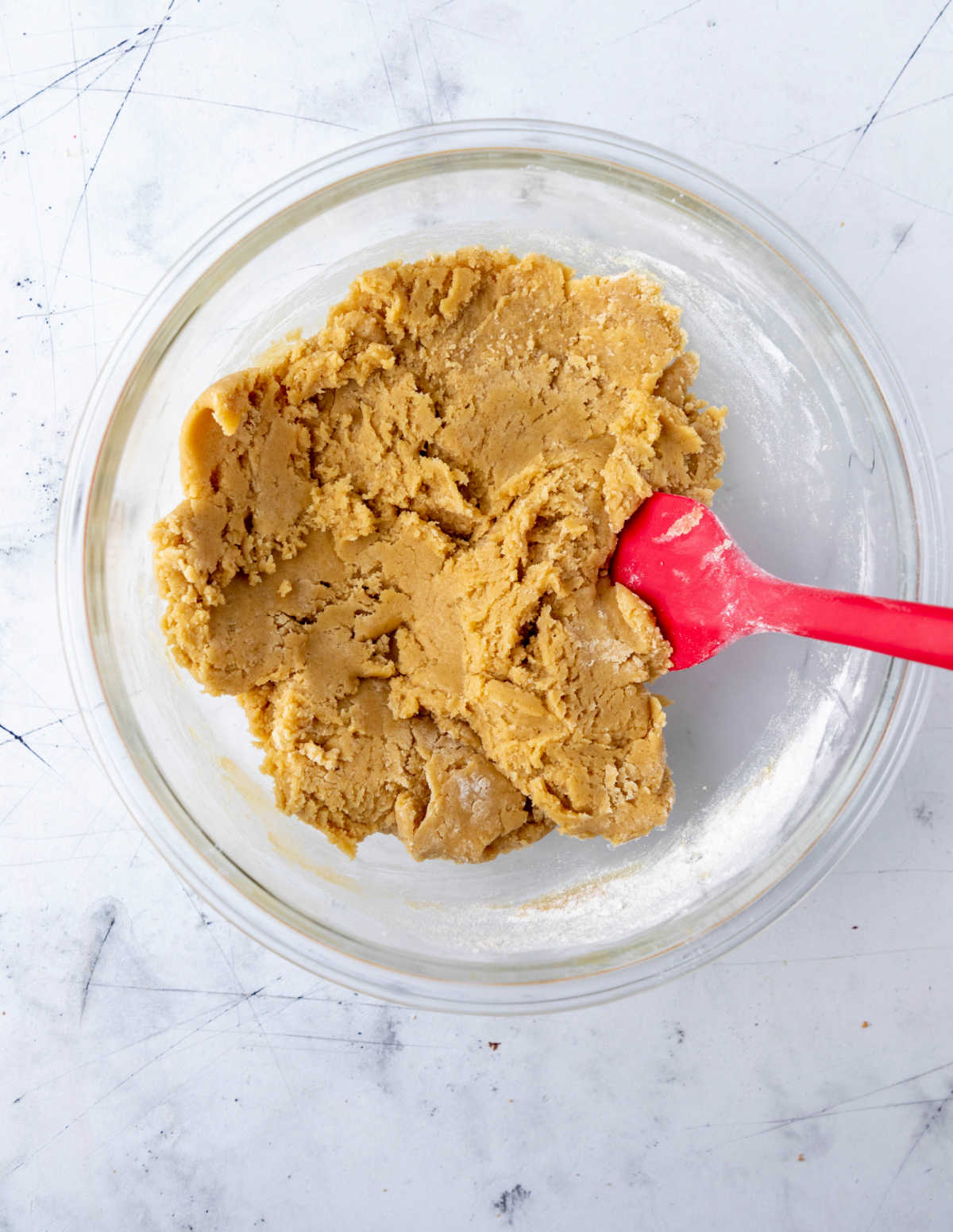 Cookie dough in a glass mixing bowl. 