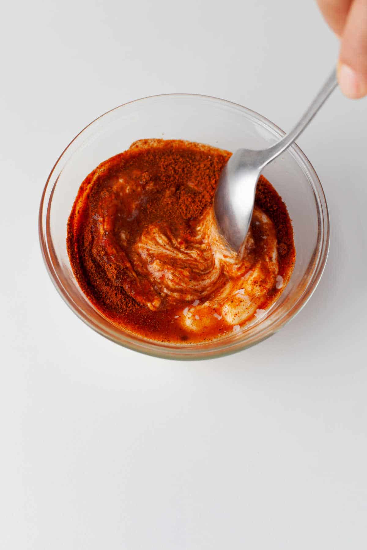 A spoon mixing up chipotle dressing. 