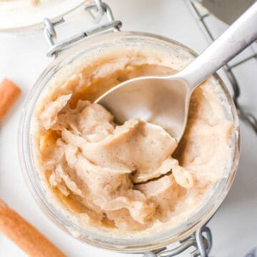 A silver spoon in a jar of Texas Roadhouse cinnamon butter.