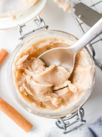 A silver spoon in a jar of Texas Roadhouse cinnamon butter.