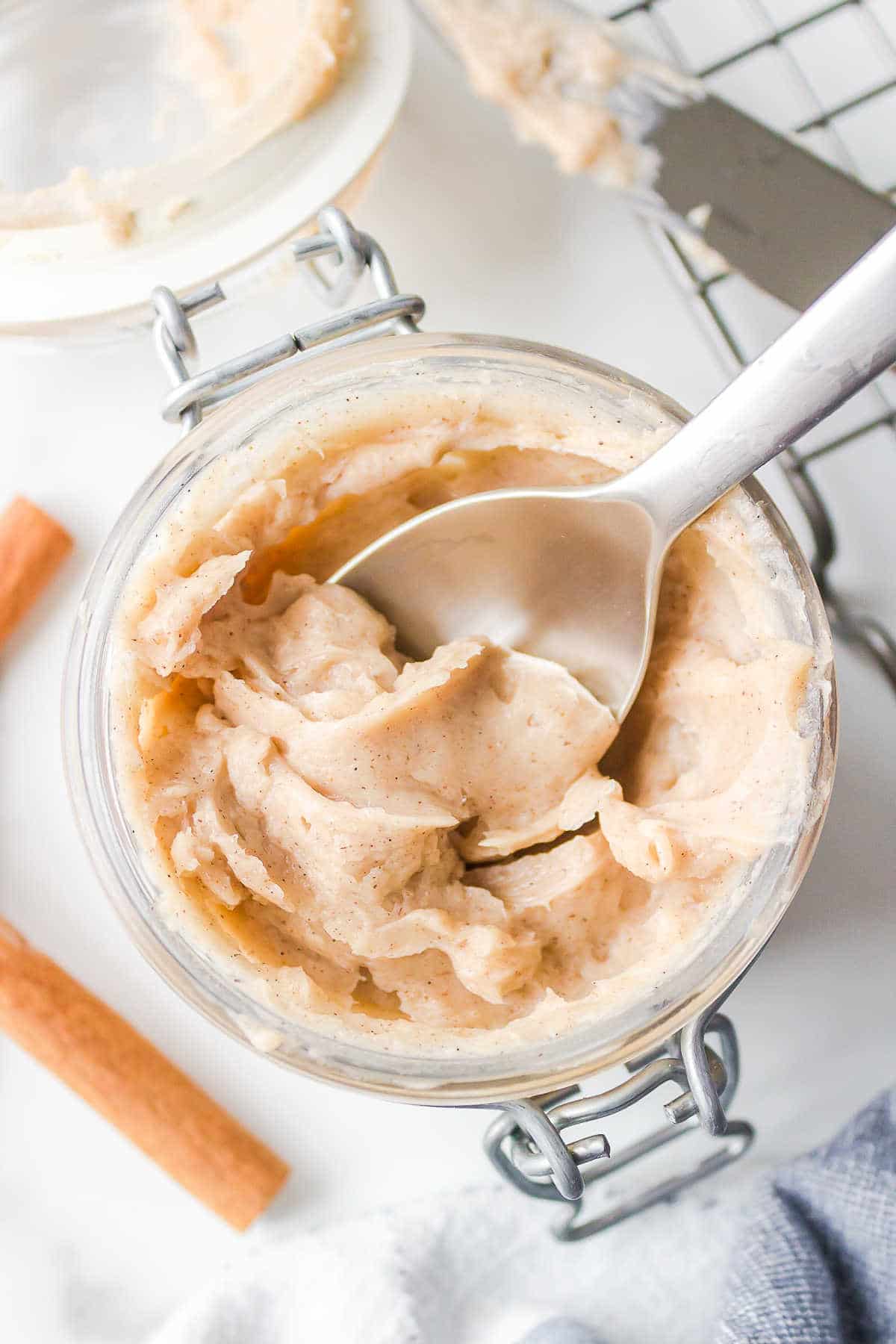 A silver spoon in a jar of Texas Roadhouse cinnamon butter.