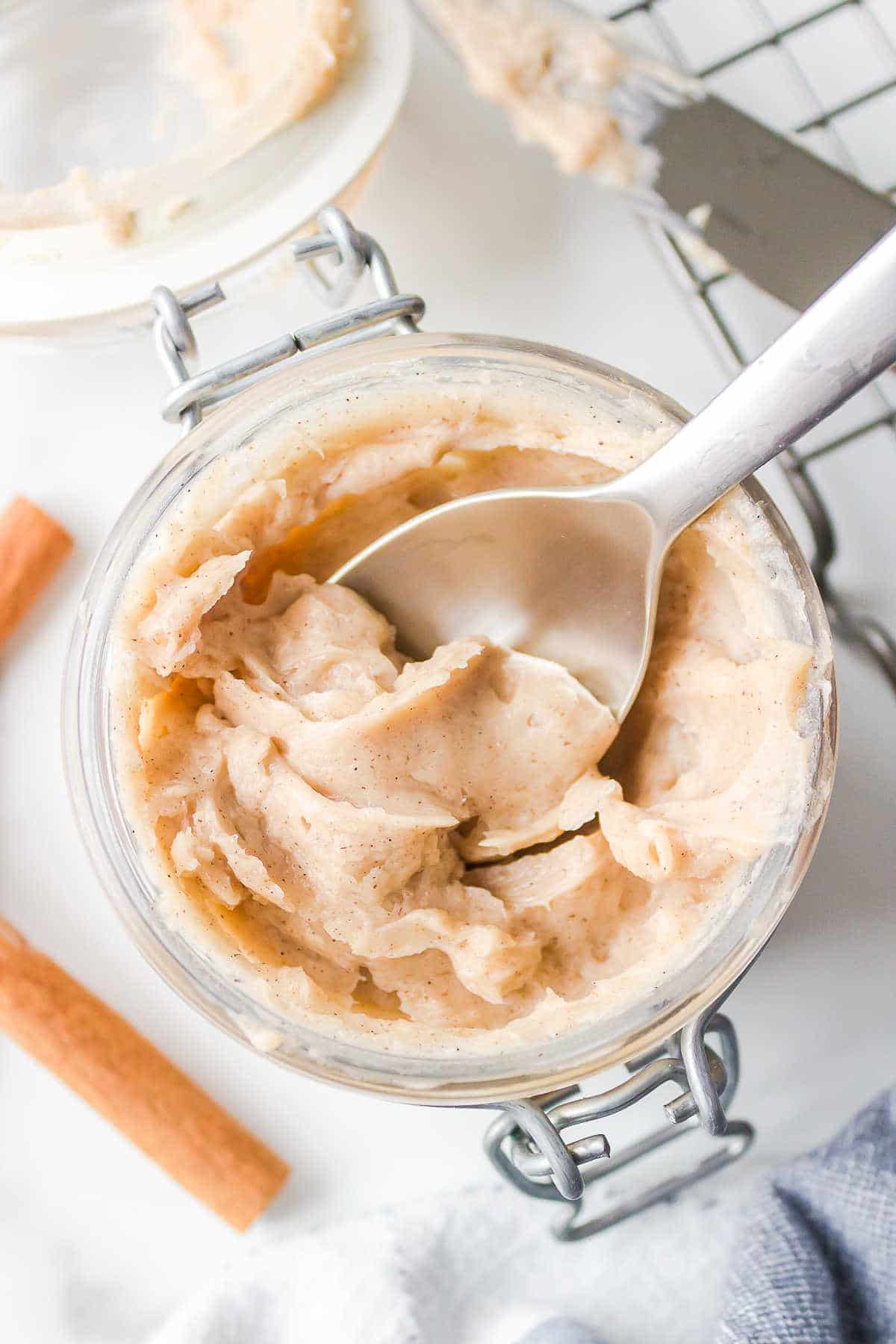 A silver spoon in a jar of Texas Roadhouse cinnamon butter. 