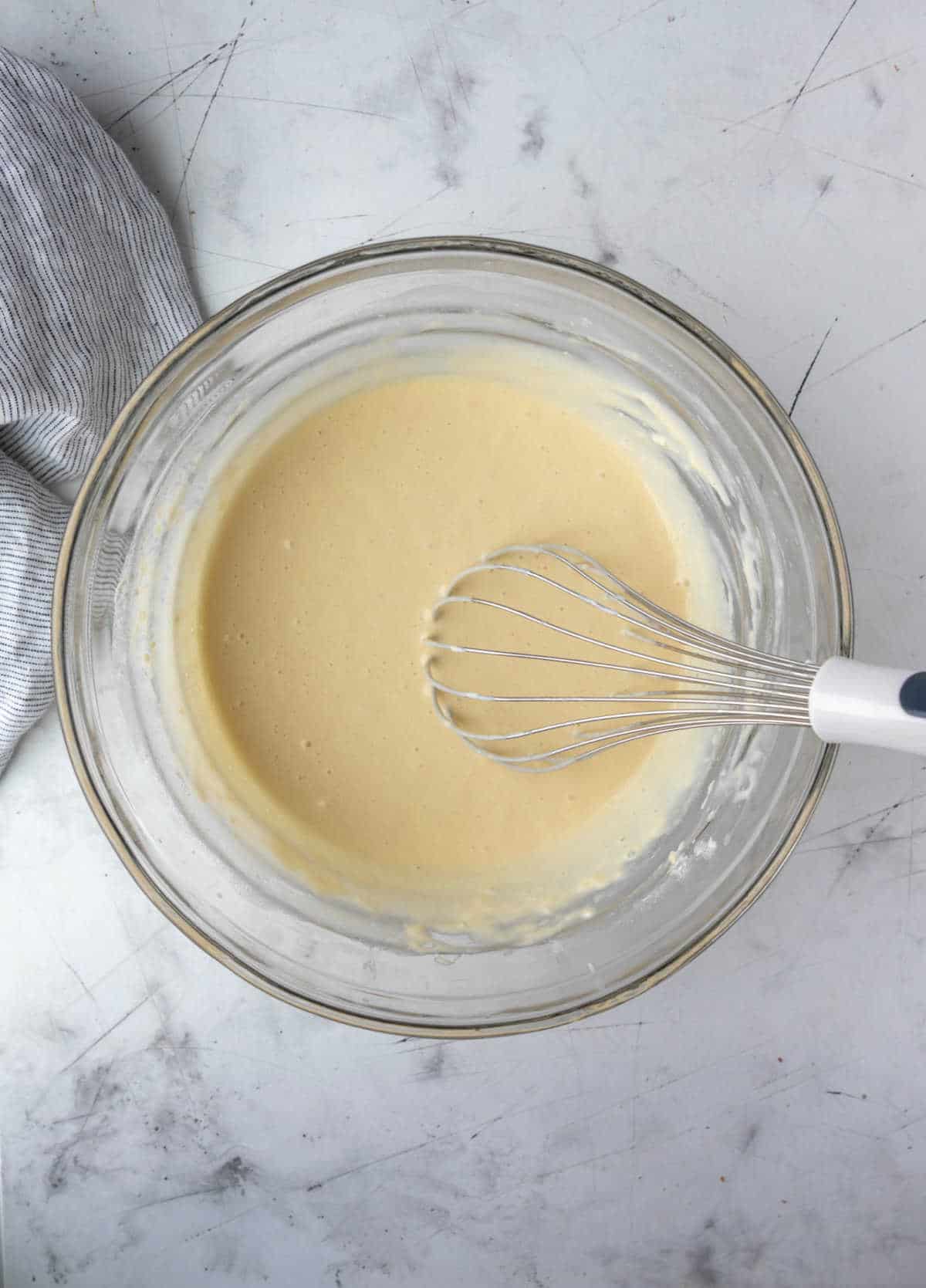 Pancake batter in a glass mixing bowl. 