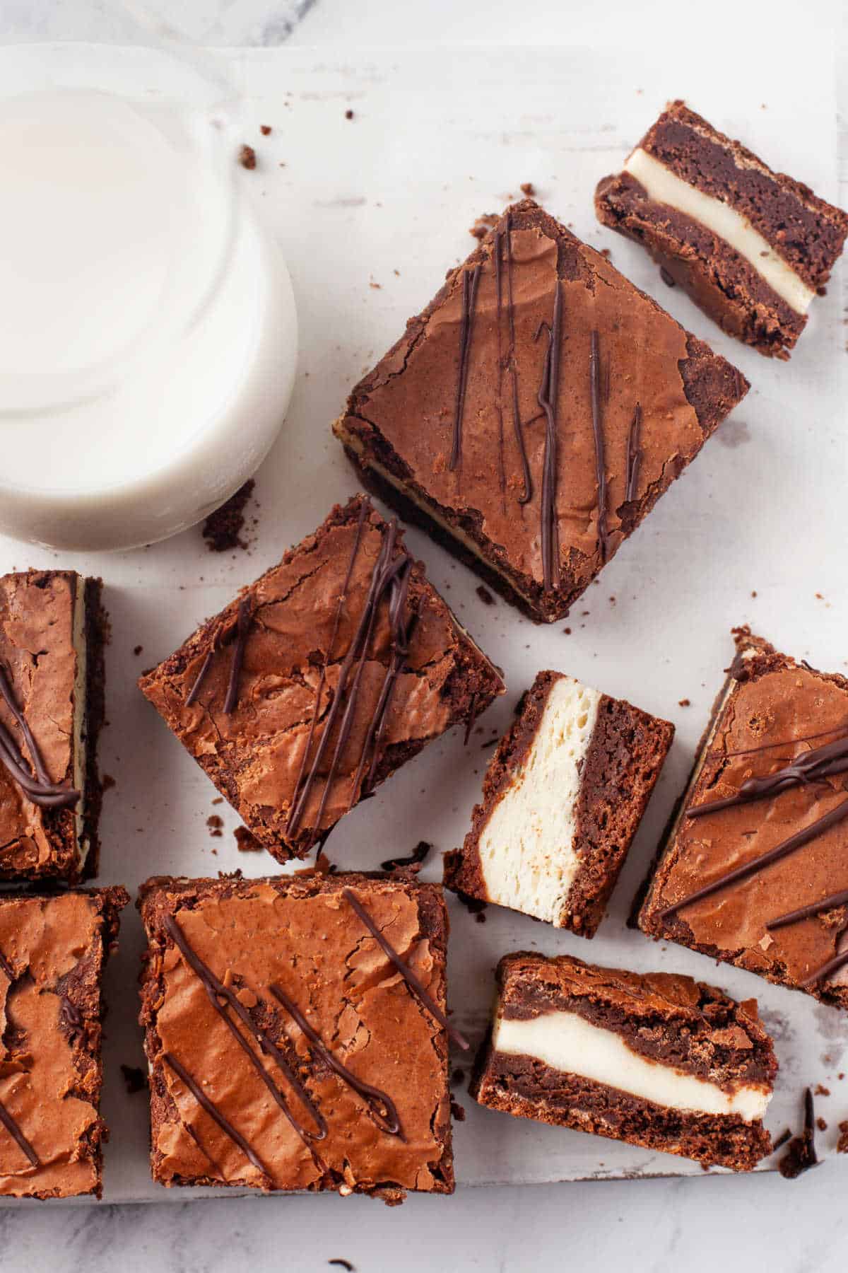 Frozen cheesecake brownies next to a glass of milk. 